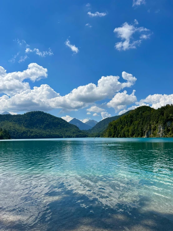 an expanse of water sits beneath a beautiful blue sky