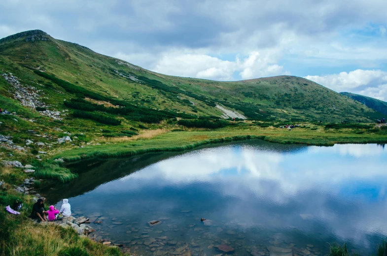 two people are fishing in a mountain lake