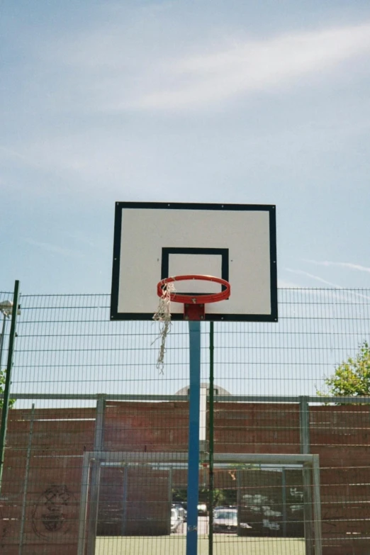 a basketball hoop and hoop mounted outside a fence