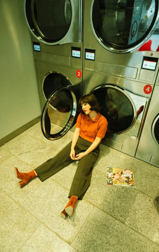 a person sitting down by a machine in the bathroom