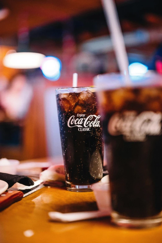 two cups of soda on a table in a restaurant