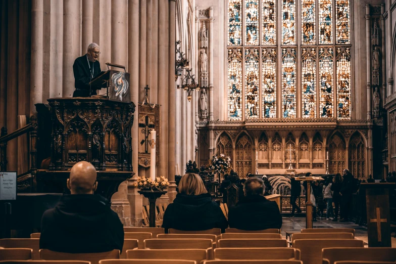 three people sitting in chairs inside of a cathedral