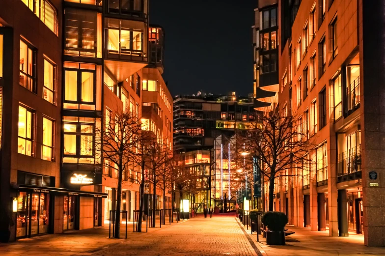 a city street lined with tall buildings at night