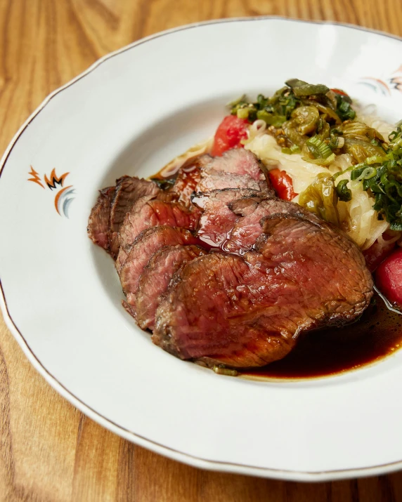 a plate topped with meat and veggies with sauce