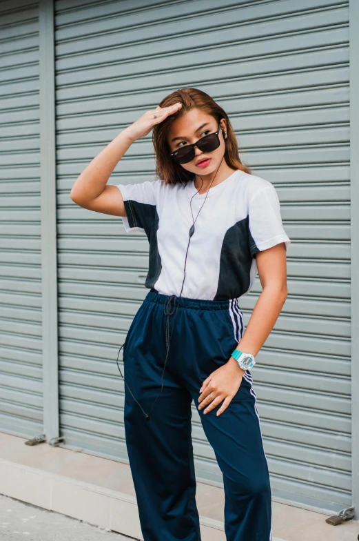 young woman in sunglasses and high waisted sweatpants on sidewalk