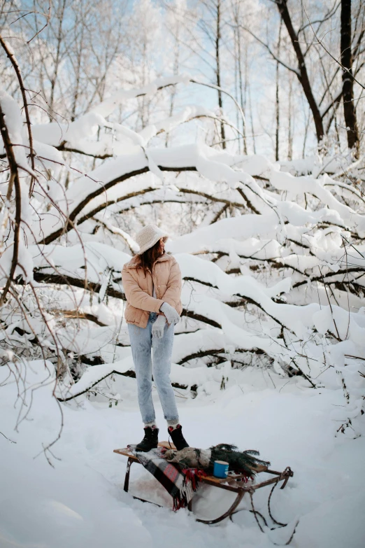 the woman is standing on a snowboard in the woods