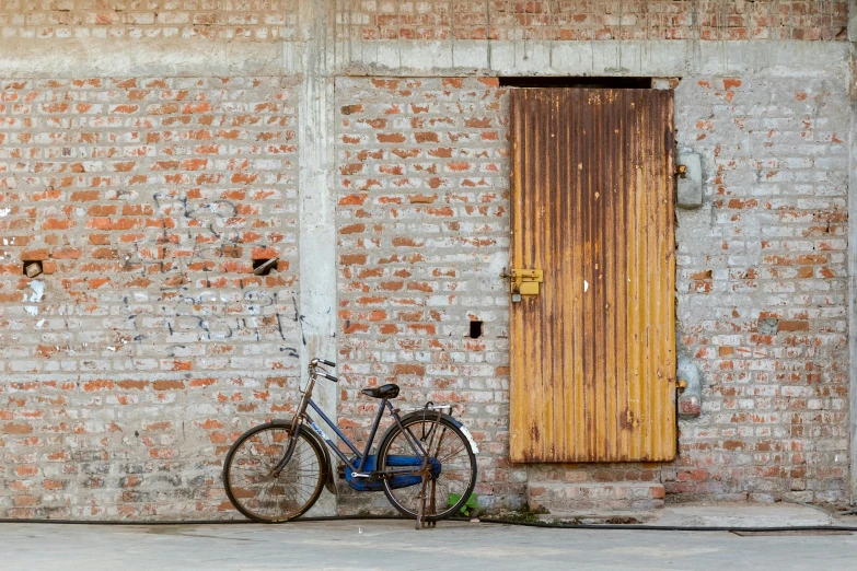 the bike is parked next to the brick wall