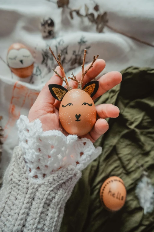 a person holding an egg with animals on it