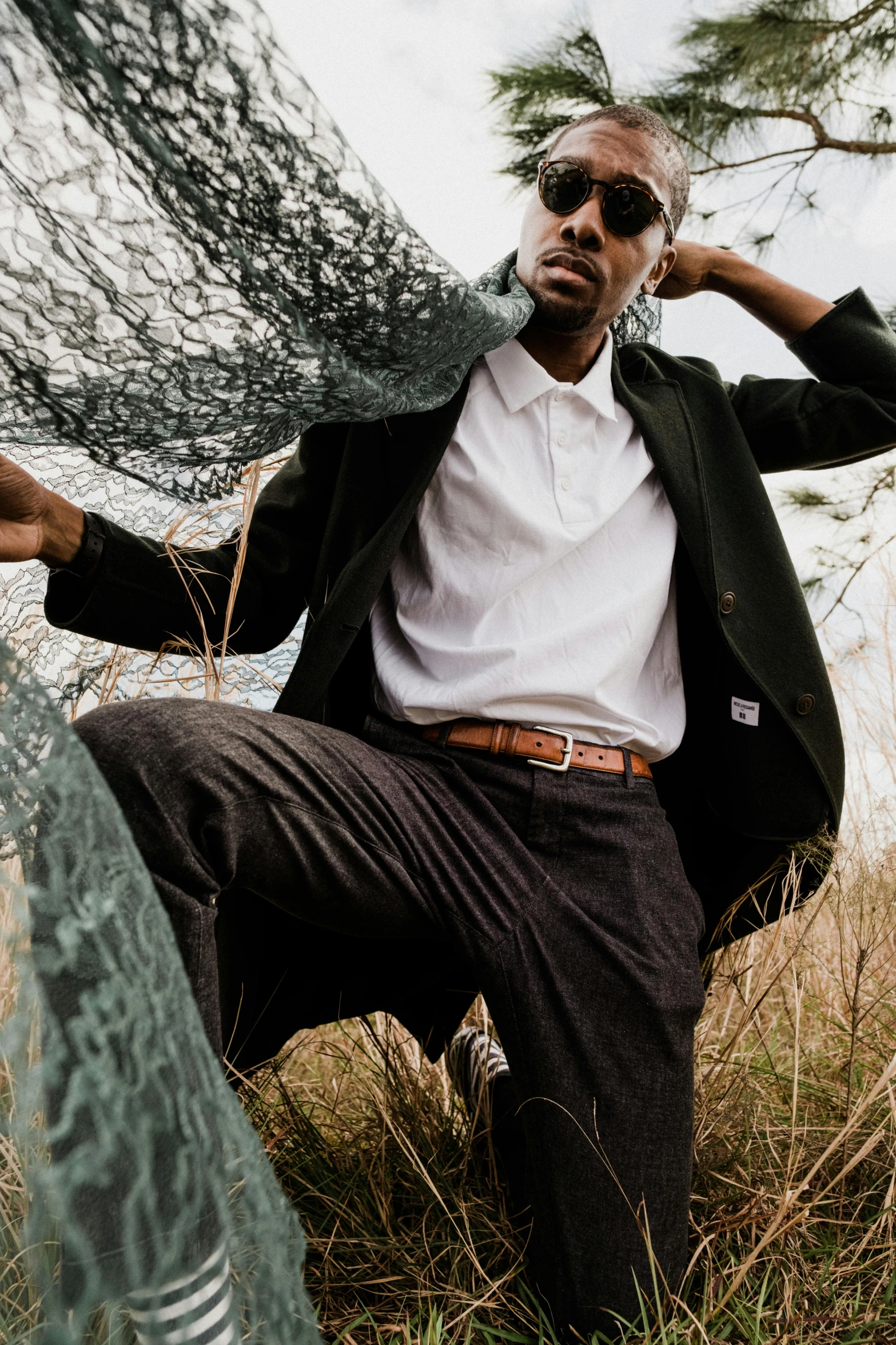 a black man sitting outside in the grass