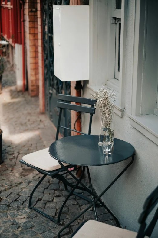 flowers and a vase on a table sitting outside