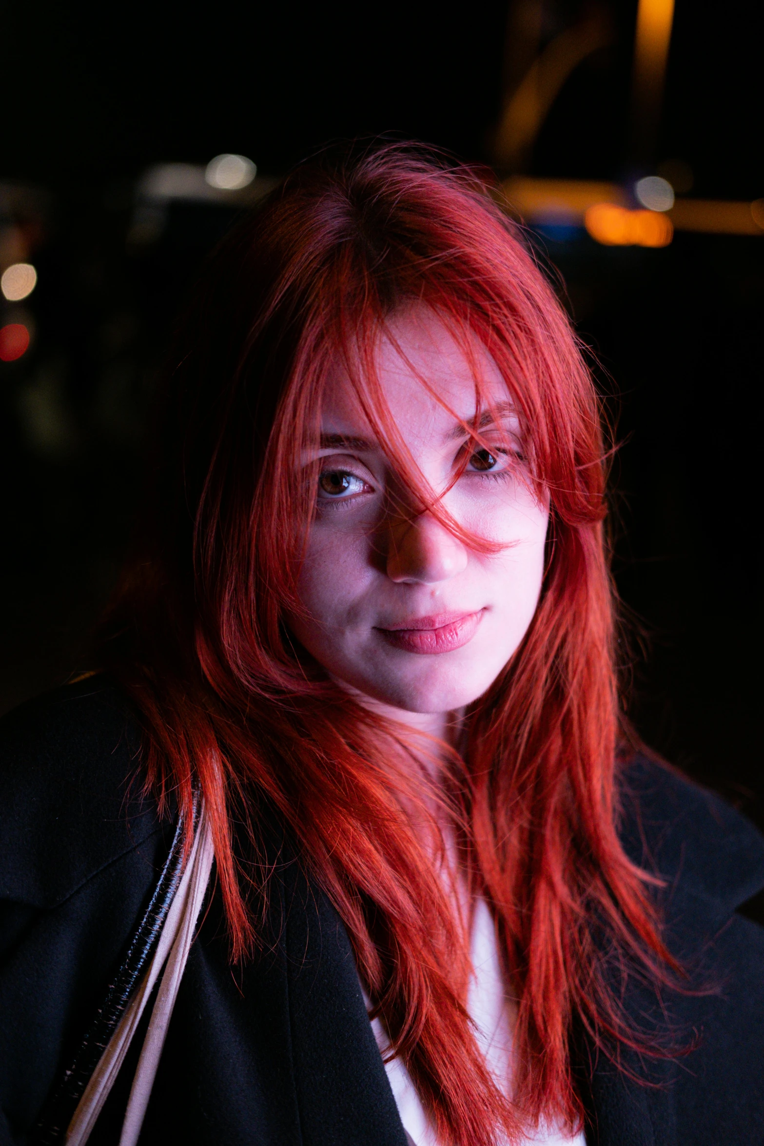 woman with red hair in dark room with hand bag on shoulder