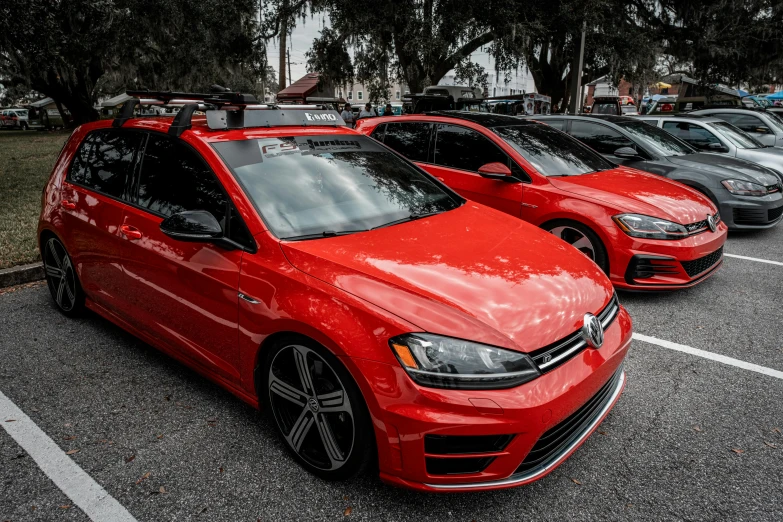 a red vw golf gti is parked in a parking lot