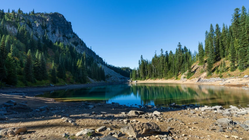 there is a small lake near a large rock wall