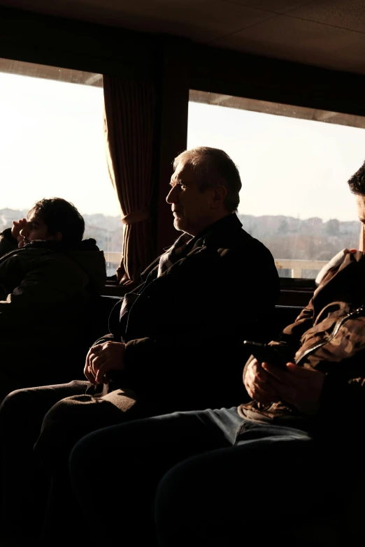 some people are sitting on train looking out the window