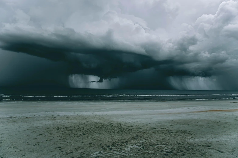 an ominous, black cloud hangs over the ocean