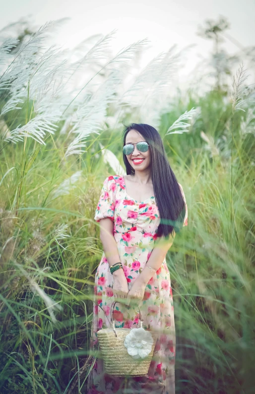 a woman in sunglasses is standing in a field