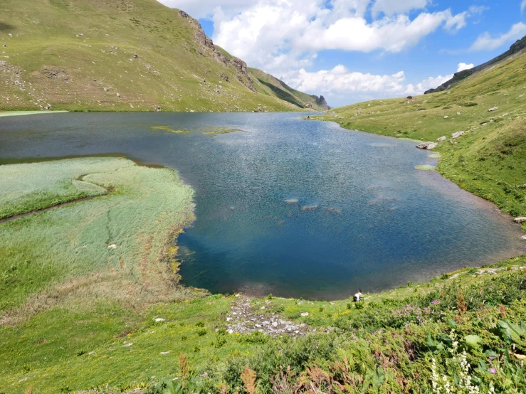 a big blue lake in the middle of a green field