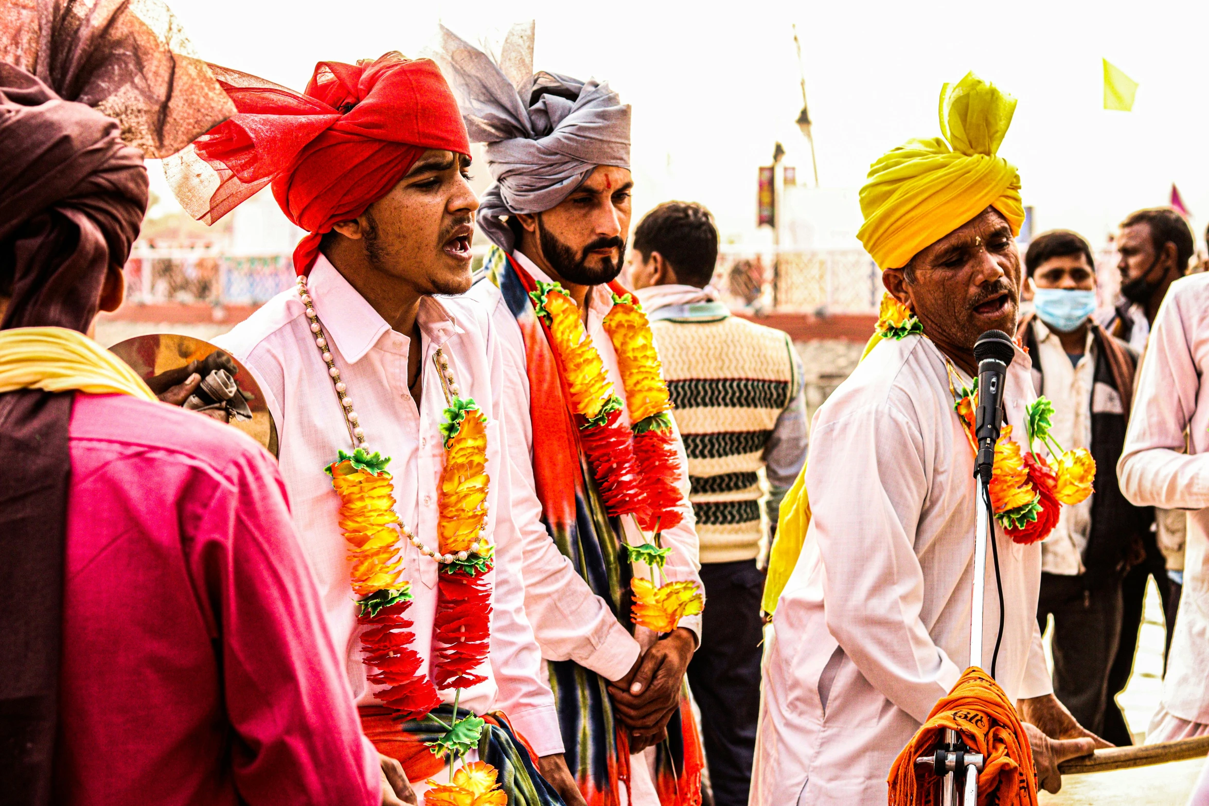 the men are wearing bright turbans with one another