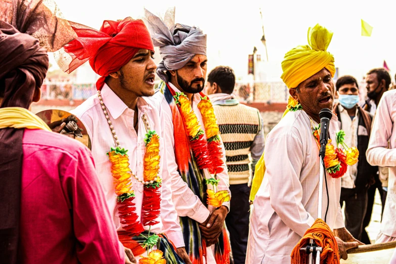 the men are wearing bright turbans with one another