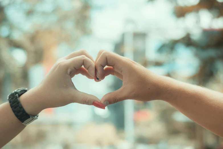 there are two hands making a heart shape