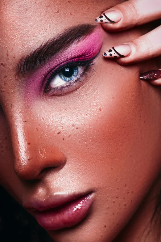 woman with pink and black eye makeup posing for a picture