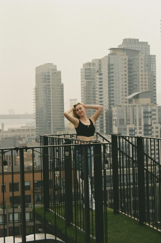 a woman in the rain wearing sunglasses on top of a balcony