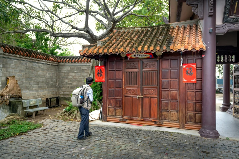 there is a man standing outside an asian building