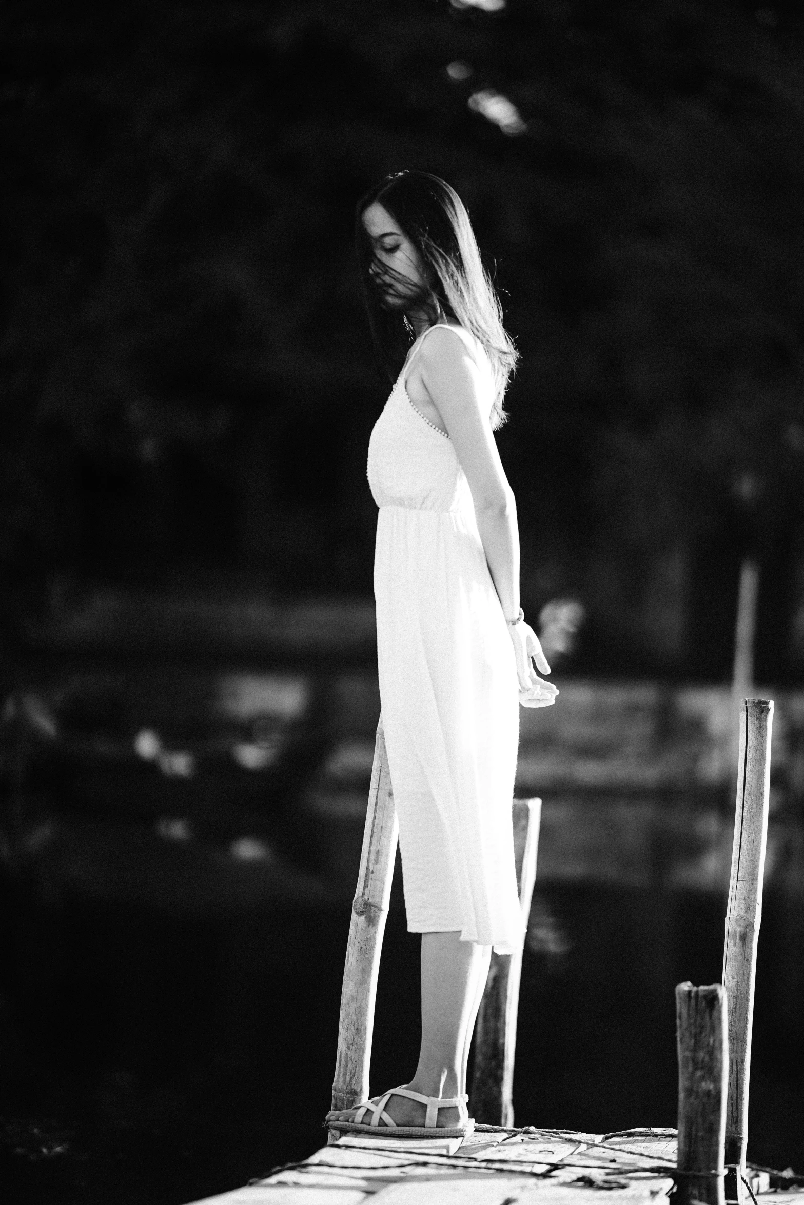 the woman is standing on the edge of the dock