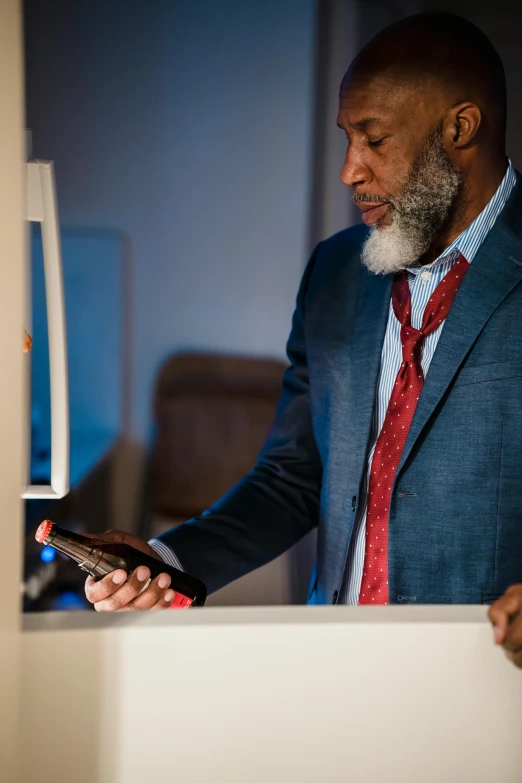 a man with a beard and a tie looking at a phone