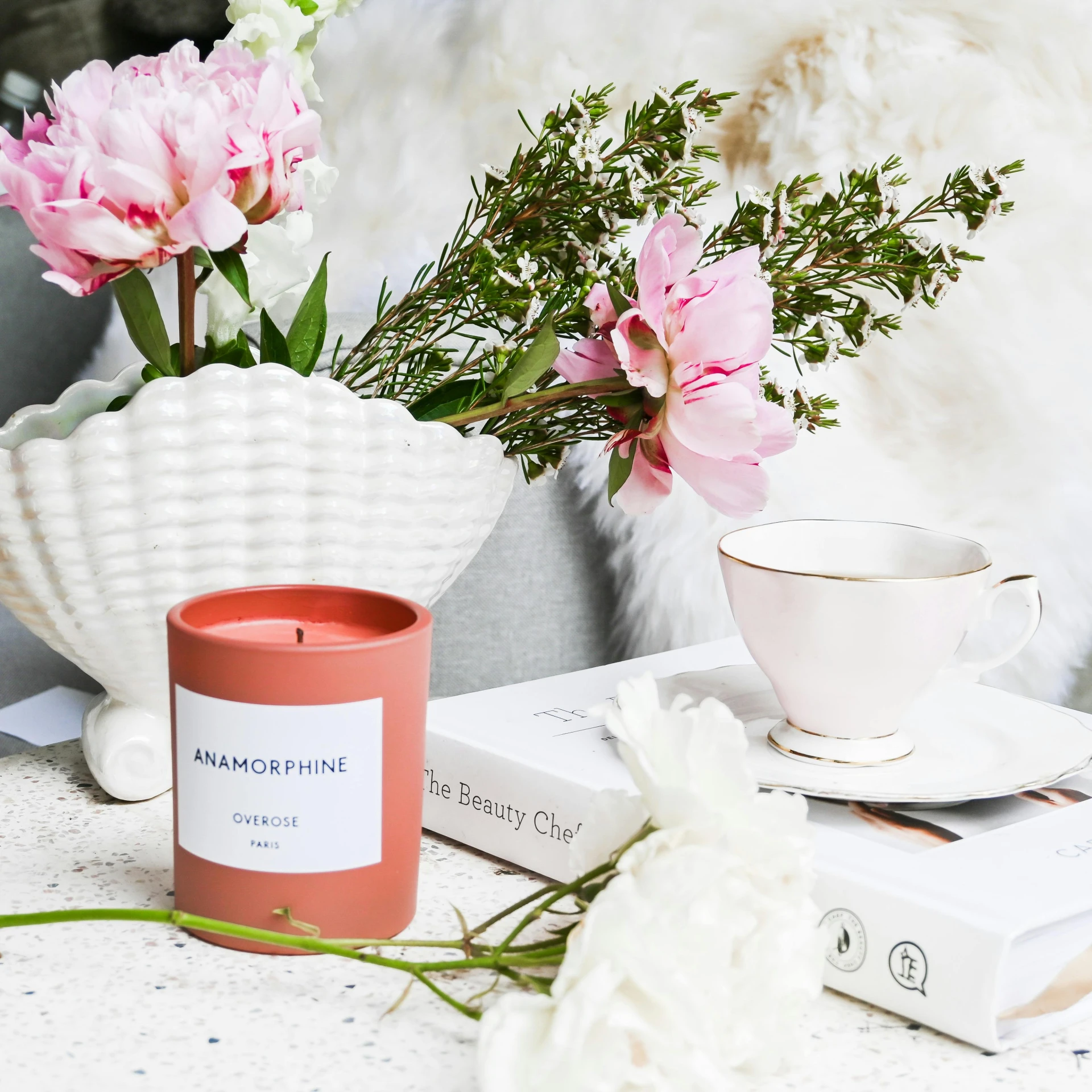 a candle on a table with flowers and books