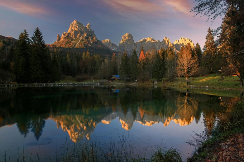 a scenic sunset is over a large body of water with mountains in the distance