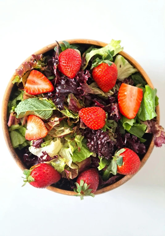 a salad with fruit on top of it in a bowl