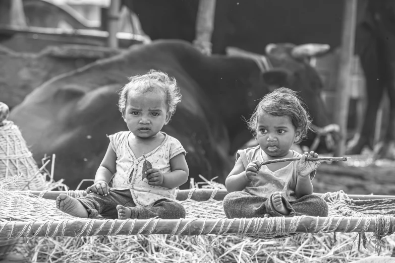 two little girls sitting in a boat full of hay