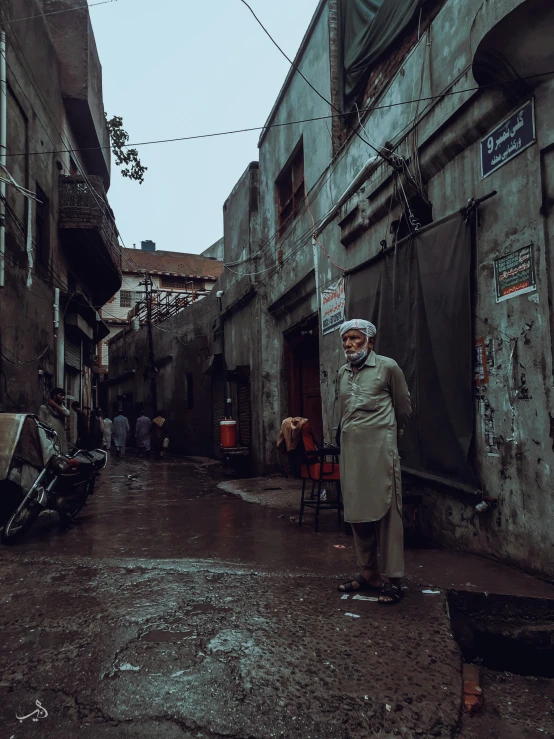 an old man walks in the narrow street