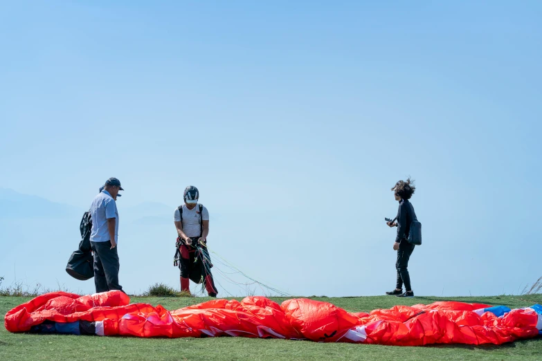 several people are standing around preparing to go para - sailing