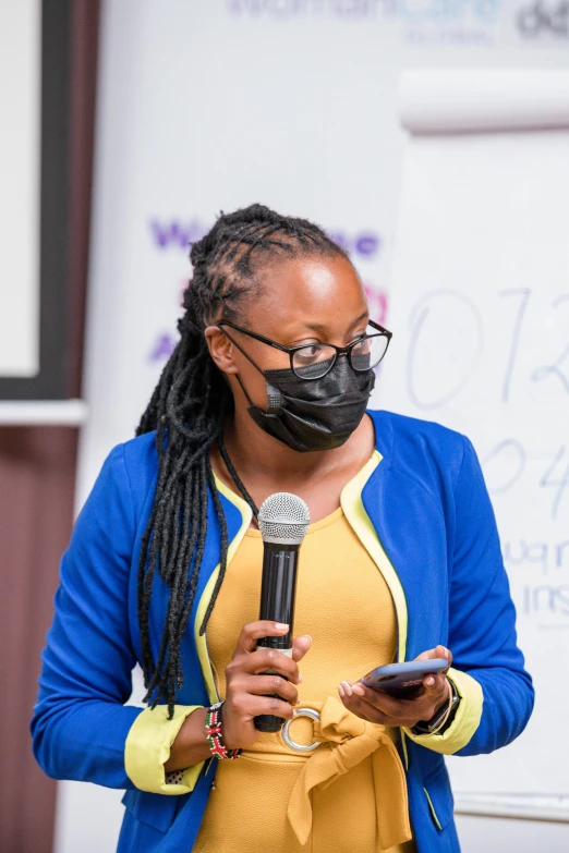 a person holding a microphone wearing a face mask