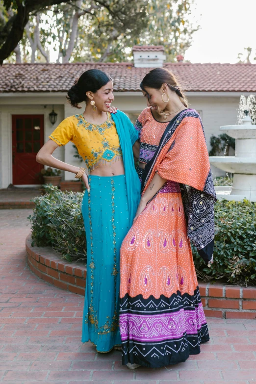 two women smiling and dressed in colorful dress clothing