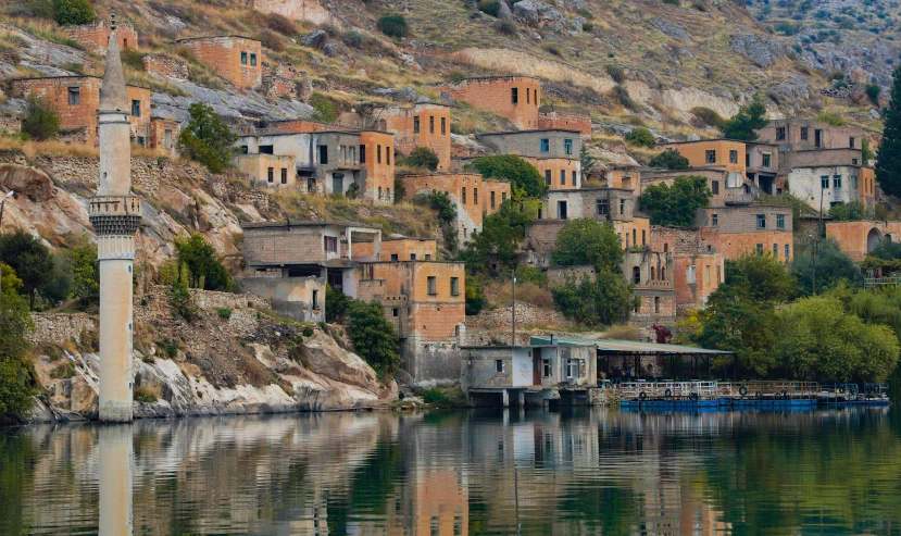 boats floating along the water in front of small brick buildings