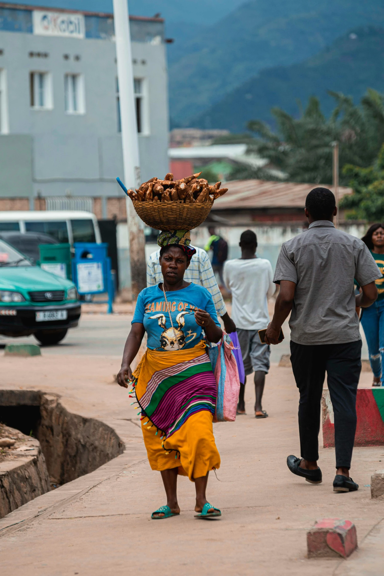 an african american woman carries soing on her head