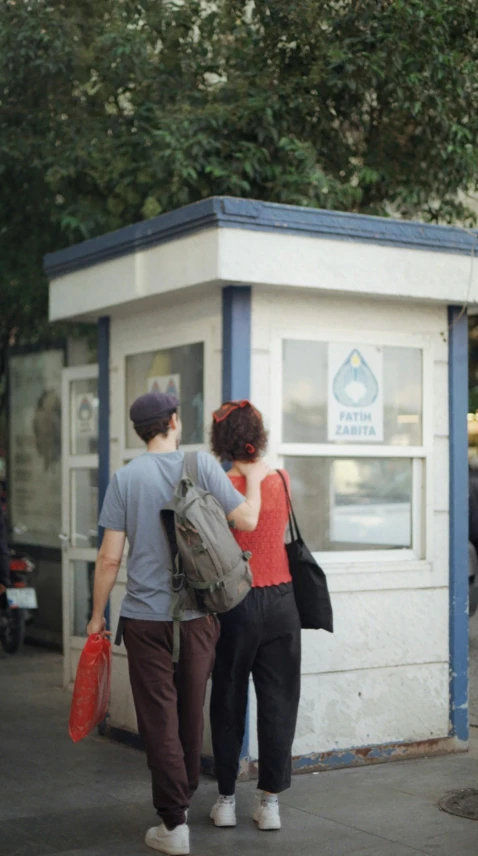 two people are walking in front of a building