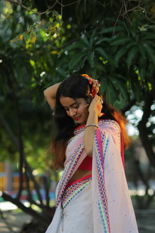 woman in white clothing is holding her hair in front of her face