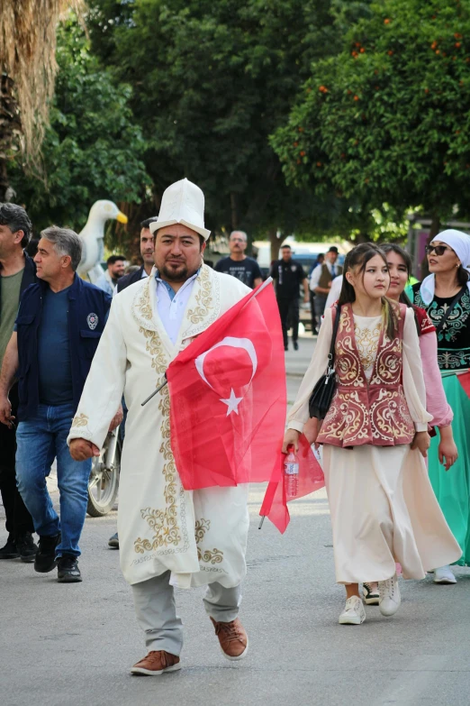 a man carrying a flag is walking among people