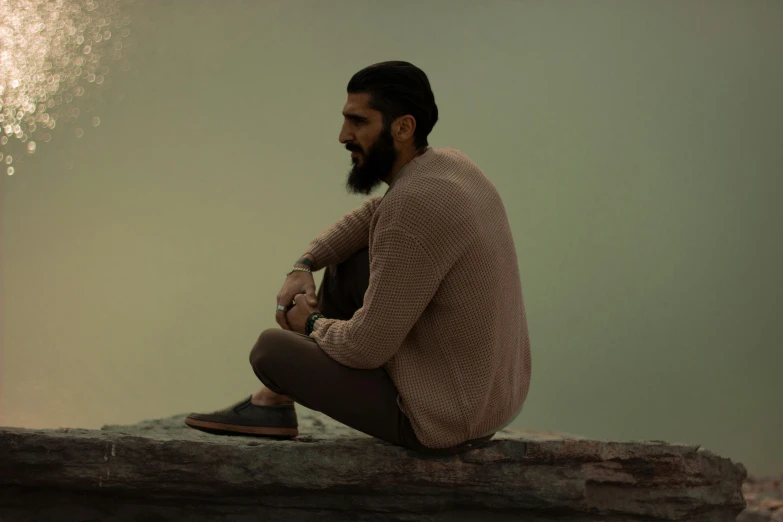 a man is sitting and watching fireworks go off in the background