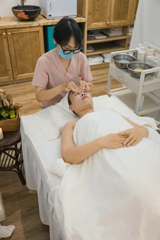 a woman getting a facial peel massage while being tended to