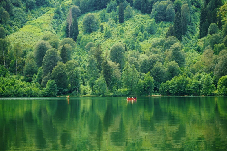 two people are in small canoes near a mountain