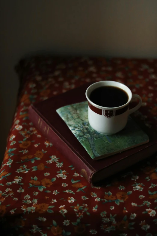 a cup of coffee is sitting on top of a book