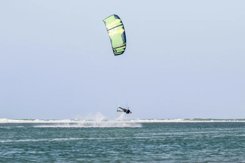 a person wind surfing on the ocean, on a clear day