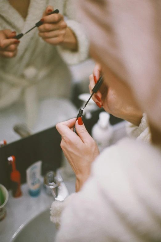 a woman is shaving her teeth in front of the mirror