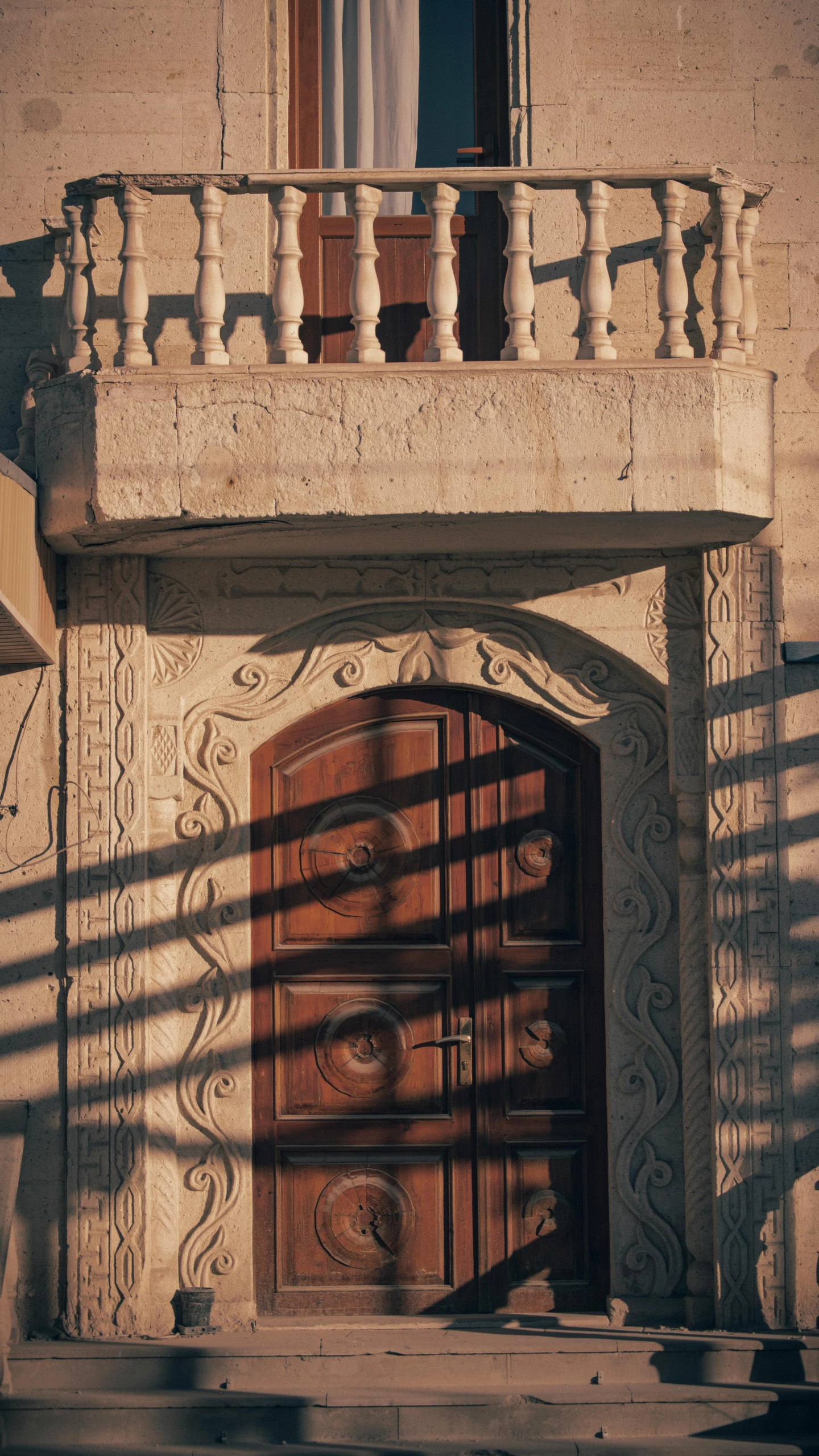 a wooden gate in front of a building with windows and a balcony