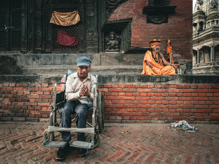 a man in a wheelchair sitting on the side of a wall
